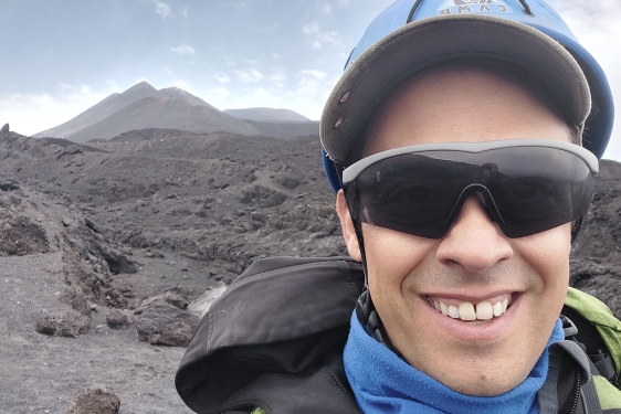 photo of man with volcanic mountain in background