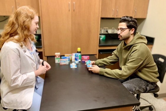 photo of two people at table with medicinal products