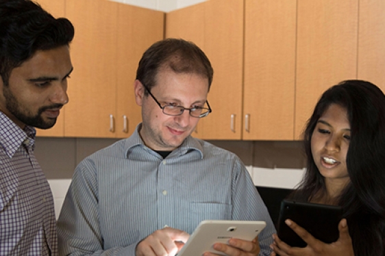 photo two men and a woman with a tablet