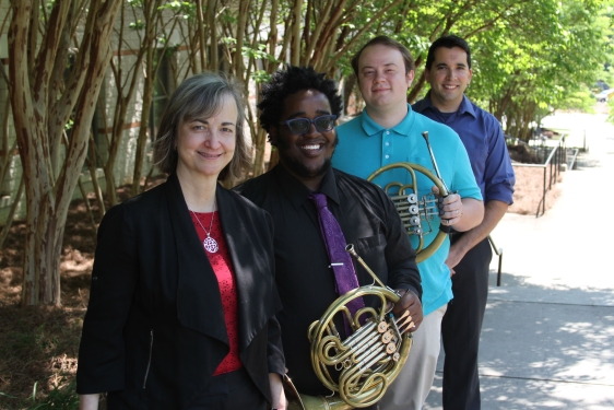 photo of four musicians, two holding horns