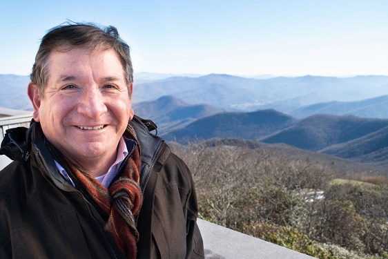 photo of man with mountains in background