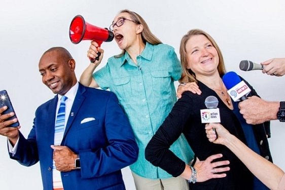 photo of man and two women, microphones, 