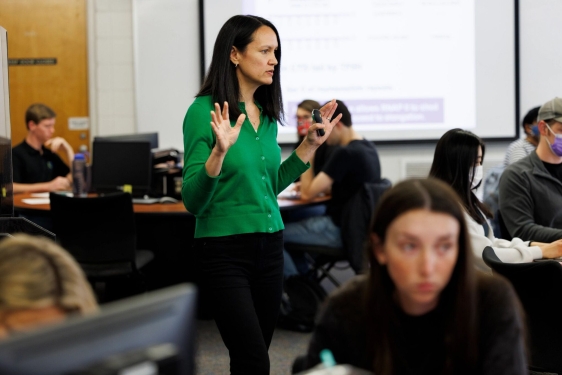 photo of woman, with students at computers