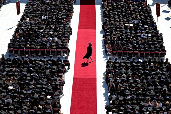 photo of student walking across red carpet at commencement