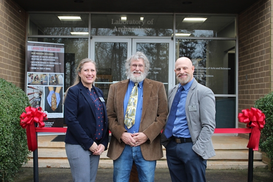 photo of woman and two men in front of building