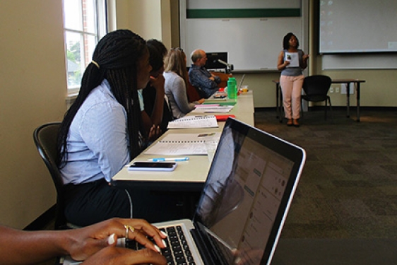 students in a classroom, macbook foreground