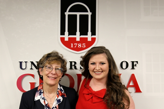 photo of two women standing in front of UGA logo