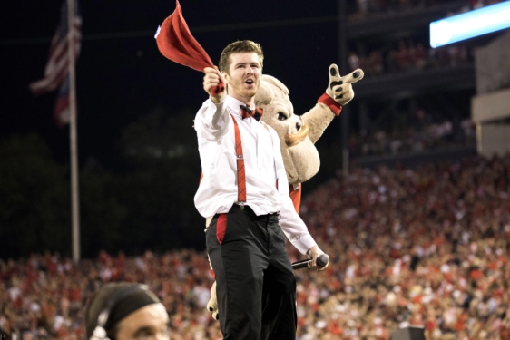 man at football game with mascot, crowd