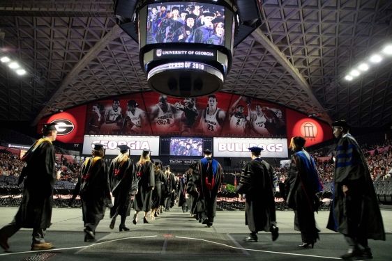 photo of people in caps and gowns inside the coliseum