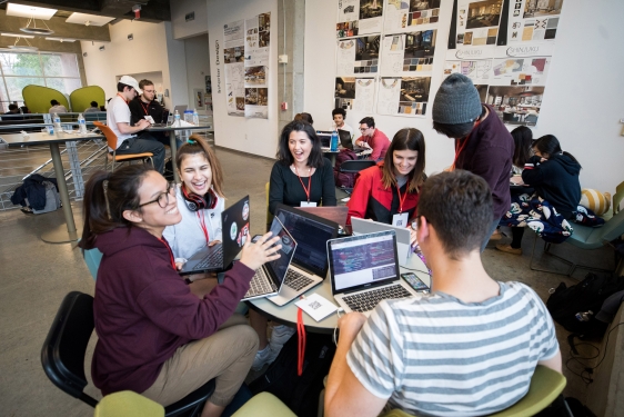 photo of people around a table with laptop computers