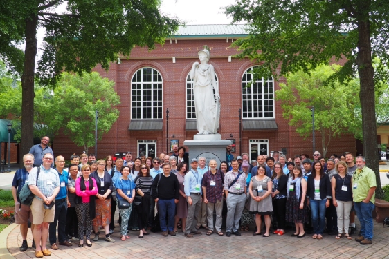 photo of large group of people with statue outdoors