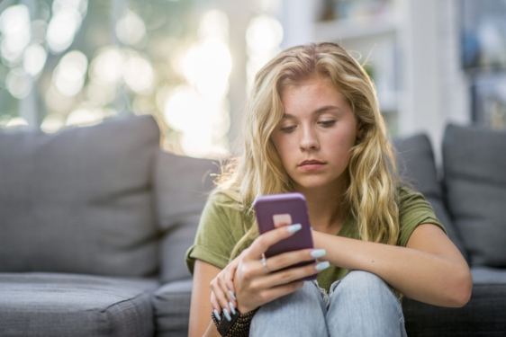 Photo of woman seated looking into cell phone