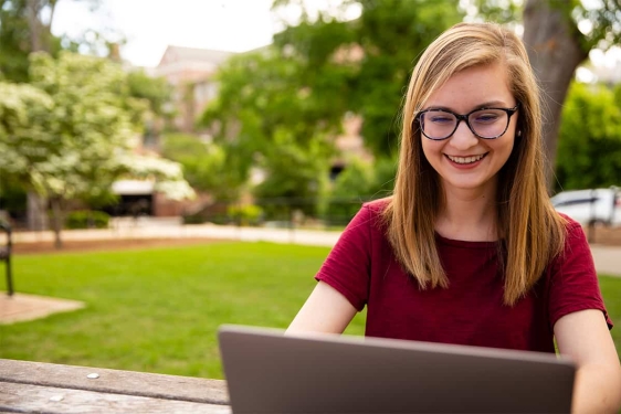 photo of woman outdoors with laptop computer