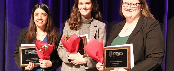 photo of three women holding plaques at ceremony