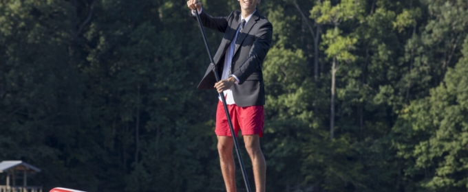 photo of man in coat and tie on lake