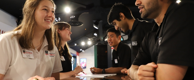 photo of people talking cross desk