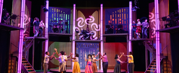 photo of stage play play production with people, lighted columns and steps