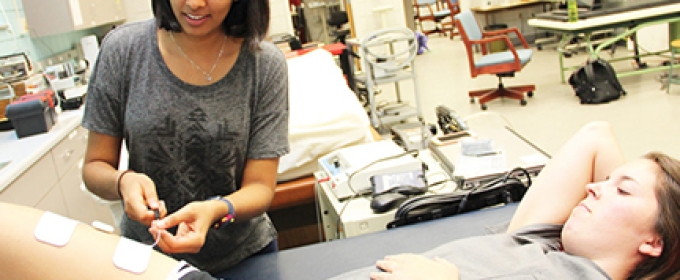 Photo one woman treating another in a lab