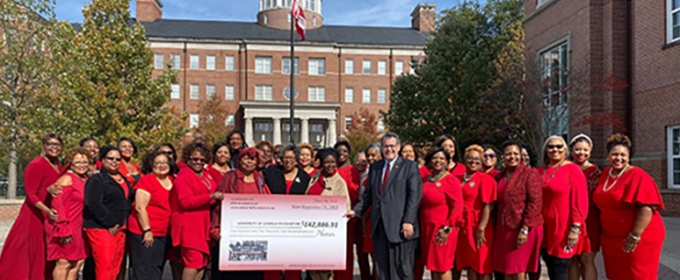 group photo of women wearing red, outdoors, with blue sky and large check