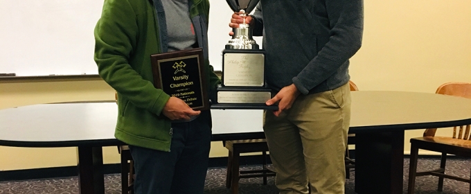 photo of two men with trophy and plaque