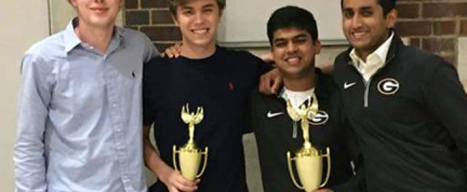 four male students with trophies