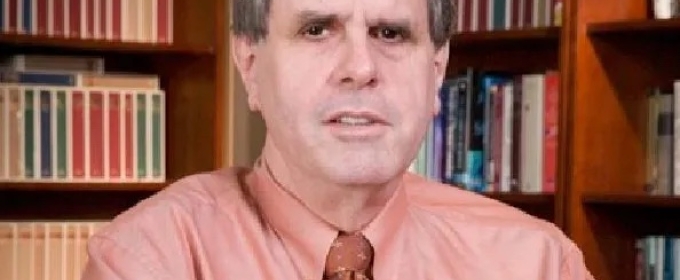 photo of man with books in background