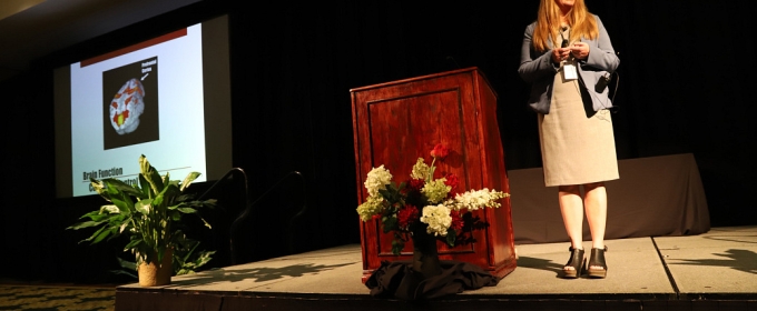 photo of woman next to podium on dais