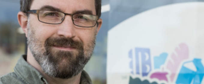 photo of man in front of sign in store window