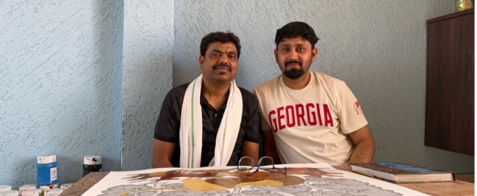 photo of two men, with drawing on table