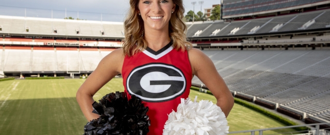 photo of woman in cheerleading outfit at stadium