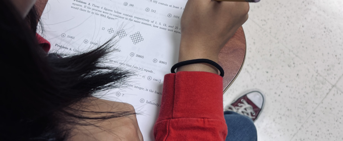 photo of person working match problems on paper with pencil