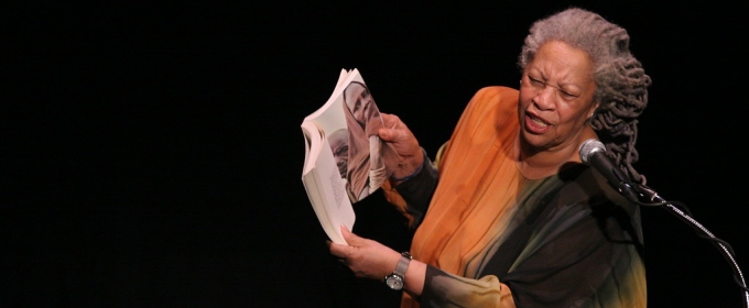 photo of woman reading aloud at a podium with mic