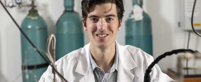 photo of man in lab coat, with lab equipment