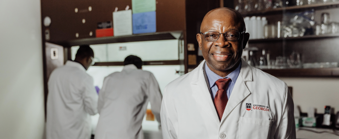 photo of man in lab, with two people in background