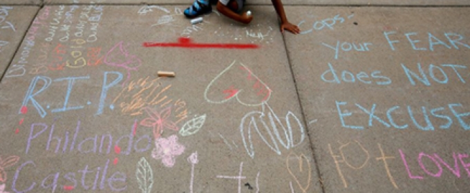 little boy drawing on a sidewalk