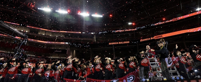 photo of marching band members in seats at stadium