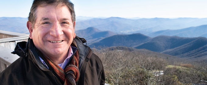 photo of man with mountains in background