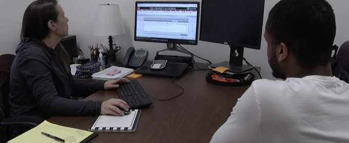 photo of two people in office with computer