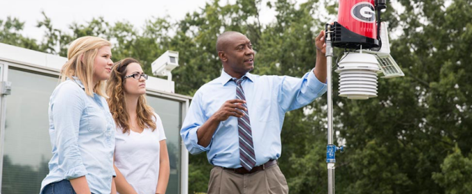 photo of man with student son rooftop weather station