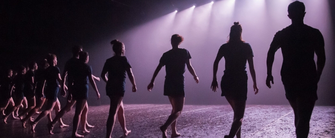 line of dancers on stage, with lights - photo from upstage