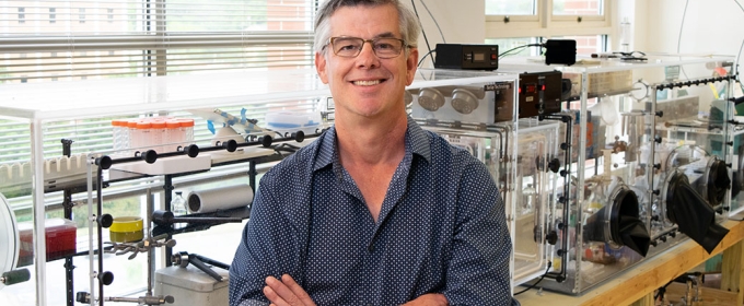 photo of man in research lab, arms folded