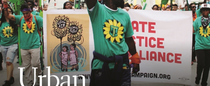 photo of man at protest, with arm raised, with signs and banners in city 