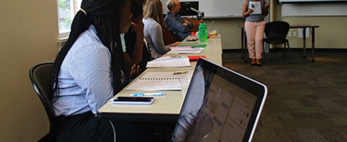 students in a classroom, macbook foreground