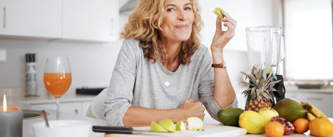 photo of woman leaning on counter, with healthy fruits