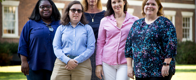 photo of four people in front of a building