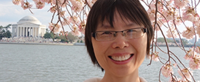 photo of woman with cherry blossom and Lincoln memorial in background