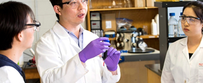 photo of man and students in lab coats