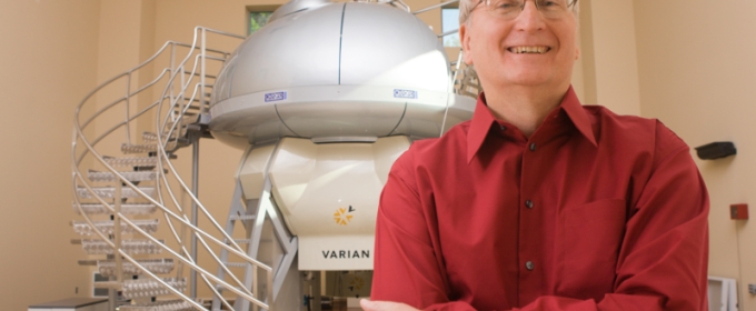 Photo of man standing in front of NMR machine