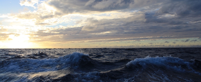 photo of breaking waves in ocean with clouds and sky