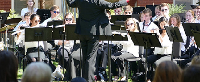 musicians playing outside, with spectators in foreground